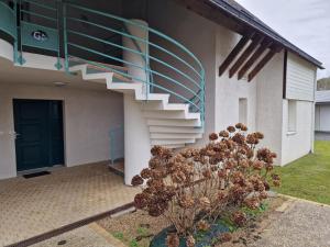 eine Treppe an der Seite eines Hauses mit einer Pflanze in der Unterkunft Appartement "La Mouette" 3 etoiles in Saint-Philibert