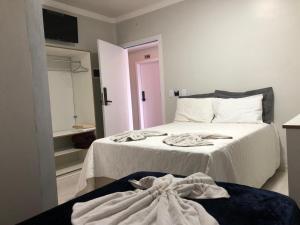 1 dormitorio con 1 cama con toallas en GUARANY HOTEL PONTA PORÃ en Ponta Porã