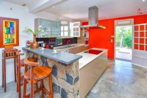 uma cozinha com paredes vermelhas e um balcão de pedra em AGREABLE VILLA DU DIAMANT em Le Diamant