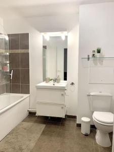 een badkamer met een toilet, een wastafel en een bad bij Grand F3 à 30mn de Paris - Terrasse + Parking privé in Saint-Ouen-lʼAumône