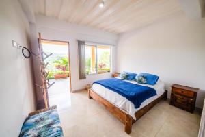 1 dormitorio con cama y ventana grande en Tambo Eco Hotel, en La Vega