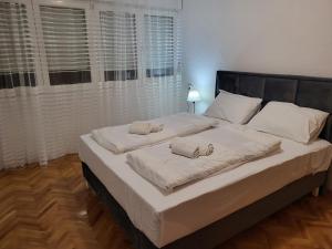 ein Schlafzimmer mit einem großen Bett mit zwei Handtüchern darauf in der Unterkunft Apartman Andjela in Tivat