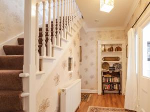 a staircase in a home with a book shelf at The Larches in Kingussie