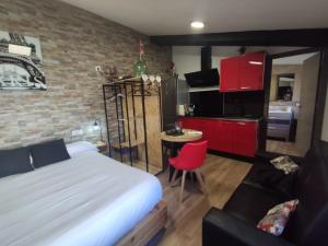 1 dormitorio con cama, mesa y cocina en CASA RURAL LA ZZINETINA en Constantina