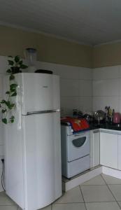 a kitchen with a white refrigerator and a stove at Apartamento inteiro 2 quartos Wi-Fi in Montes Claros
