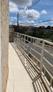 a balcony with a fence and shadows on the sidewalk at Apartamento inteiro 2 quartos Wi-Fi in Montes Claros