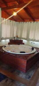 Zimmer mit einem großen Holztisch mit einem großen Doppelbett in der Unterkunft Pousada Jipe Canastra in Capitólio