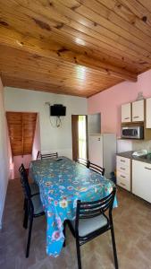 a dining room with a table and a kitchen at Ruca Epu in Las Grutas