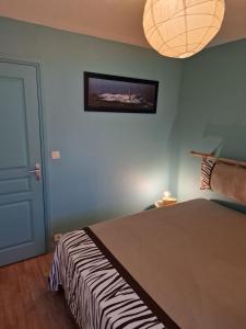 ein Schlafzimmer mit einem Bett und einem Bild an der Wand in der Unterkunft Appartement "La Mouette" 3 etoiles in Saint-Philibert