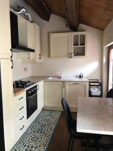 a kitchen with white cabinets and a table with chairs at Casa Sissi in Loreto