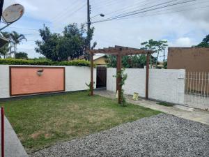 un jardín con pérgola frente a un edificio en Casa em Florianópolis, rio vermelho de 2 quartos bem localizada, en Florianópolis