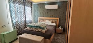 een kleine slaapkamer met een bed en een raam bij shehab - residence Hotel apartment in Caïro