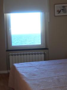 a bedroom with a window with a view of the ocean at Casa Tabata fronte mare in Genoa