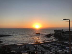 a sunset on a beach with the sun setting over the ocean at Casa Tabata fronte mare in Genoa