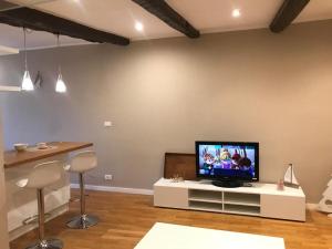 a living room with a television on a white entertainment center at Casa Tabata fronte mare in Genoa
