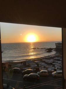 a view of a beach with cars parked in front of the ocean at Casa Tabata fronte mare in Genoa