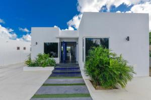 a white house with a blue door at A Serene Retreat with Modern Amenities in Santa Cruz