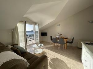 a living room with a couch and a table with chairs at Illyrian Resort in Milna