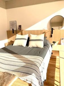 1 dormitorio con 1 cama grande y cabecero de madera en Stylish Apartment by River with Pool & Grill in 