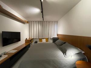 1 dormitorio con 1 cama y TV de pantalla plana en Conforto e praticidade próximo à Oscar Freire, en São Paulo