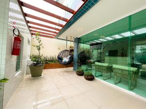 a large room with a table and chairs and plants at Pousada Marítimos in Maragogi