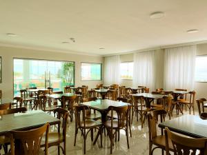 a dining room with tables and chairs and windows at Pousada Marítimos in Maragogi