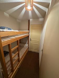 Kleines Zimmer mit einem Bett und einem Kronleuchter in der Unterkunft Appartement Les Carroz d'Araches 4 à 6 couchages in Les Carroz d'Araches