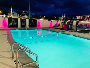 una piscina por la noche con gente de pie alrededor en Hotel ZAZZ, en Albuquerque