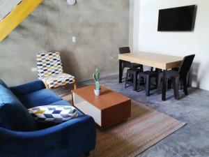 a living room with a blue couch and a table at Hellen House Bello Horizonte in Santa Marta