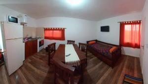 San Roque的住宿－CABAÑA LA HERRADURA 14，厨房以及带桌子和沙发的客厅。