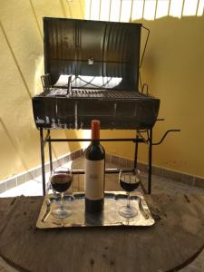 Una botella de vino y dos copas en una mesa. en NUESTRO DEPARTAMENTO en Godoy Cruz