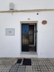 un accès à un bâtiment blanc avec deux portes dans l'établissement Casa Cerro Luna, à Constantina
