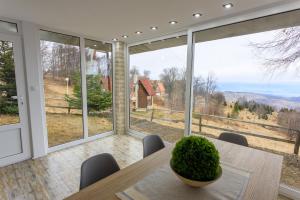 a dining room with a table and large windows at Casa Vrelo, Golija in Raška