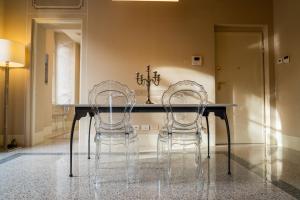 een eetkamer met 2 stoelen en een tafel bij Noble Floor - Luxury Apartments in Lucca