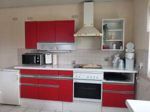 a kitchen with red cabinets and a stove top oven at Ferienwohnung Schmidt Werratal in Wanfried