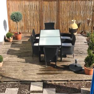 a patio with a table and chairs on a wooden deck at Ferienwohnung Romantica EG in Schopfloch