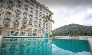 a hotel with a swimming pool in front of a building at Flat Completo Granja Brasil in Petrópolis