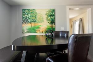 una mesa de comedor con sillas y una pintura en la pared en Cozy 2 Bedroom Home Minutes from Beach & Bars en Jacksonville Beach