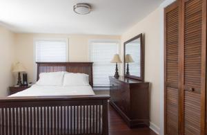 - une chambre avec un lit, une commode et un miroir dans l'établissement Cozy 2 Bedroom Home Minutes from Beach & Bars, à Jacksonville Beach
