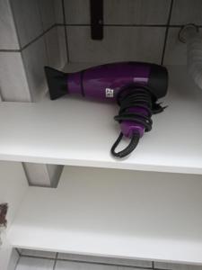 a purple blow dryer sitting on top of a counter at Aconchego in São Luís