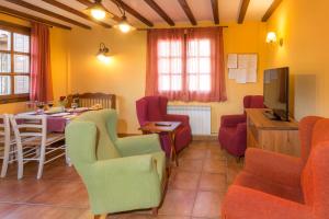 sala de estar con mesa, sillas y TV en Casa Fresneda, en Fresneda de la Sierra Tirón