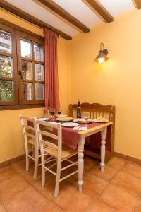 a dining room with a table and two chairs at Casa Fresneda Jardín río y parque infantil frente a la casa in Fresneda de la Sierra Tirón