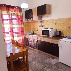 a kitchen with a table and a microwave at Corfu Sunflower Apartments in Benitses
