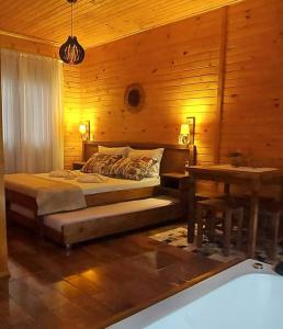 1 dormitorio con 1 cama y pared de madera en Pousada Recanto Das Araucárias, en Bocaina do Sul
