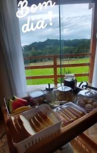 a table with a tray of different types of food at Pousada Recanto Das Araucárias in Bocaina do Sul
