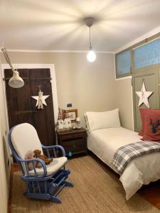 ein Schlafzimmer mit einem Bett und einem Schaukelstuhl in der Unterkunft Il Riccio appartamento in Cernobbio