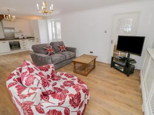 a living room with a couch and a tv at Stonehaven in Kidderminster