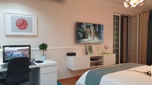 a bedroom with a bed and a desk with a computer at StayCozy in Lisbon