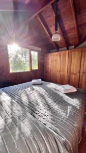Una cama o camas en una habitación de El Abedul Cabaña en La Cascada, SMA
