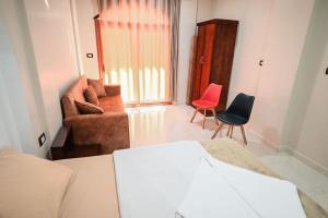 um quarto com uma cama, um sofá e uma cadeira em Kana Kato em Aswan